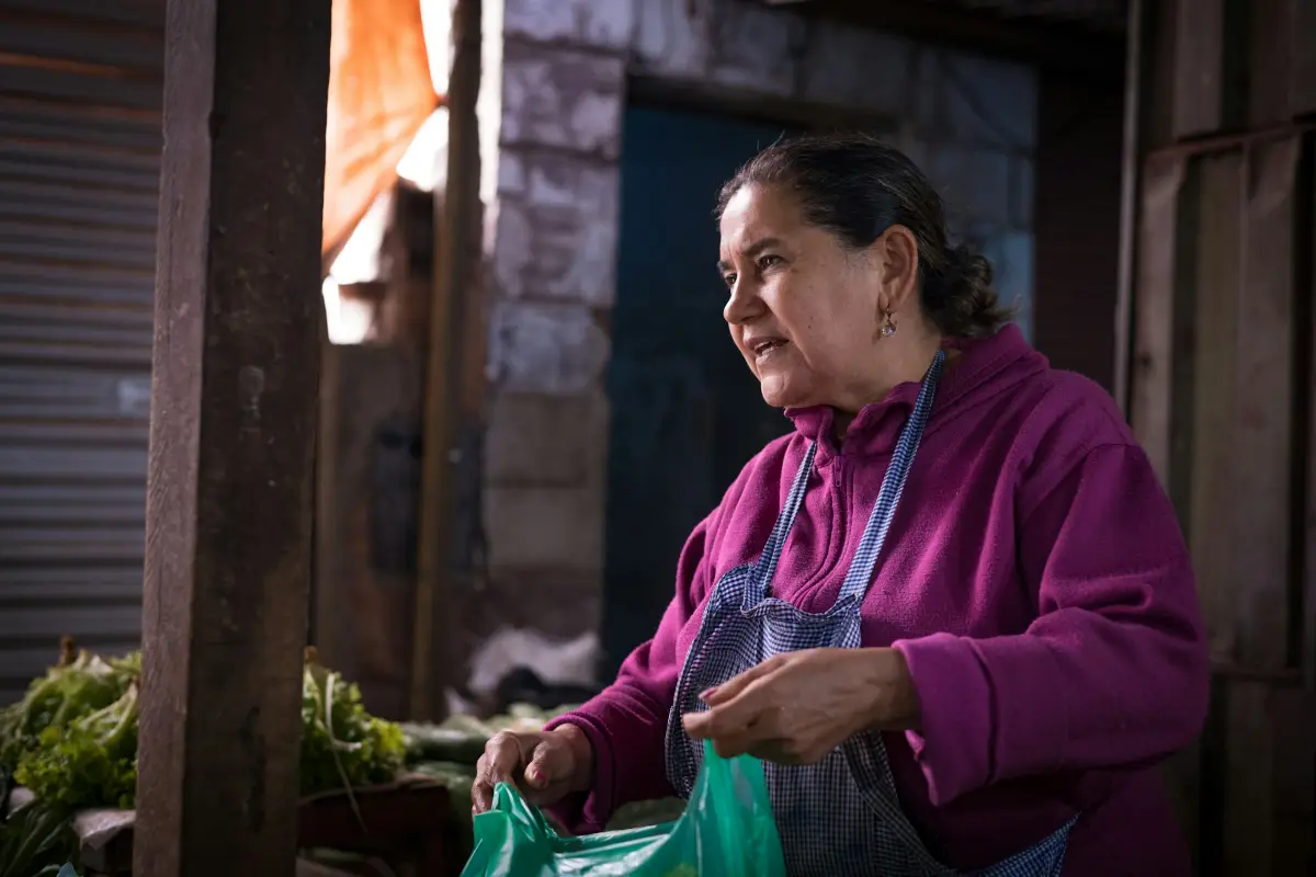 Una vendedora prepara verduras en un mercado de Asunción